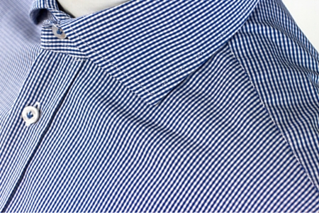 Close up of collar and shoulders of a tailored men's checkered shirt with cutaway collar