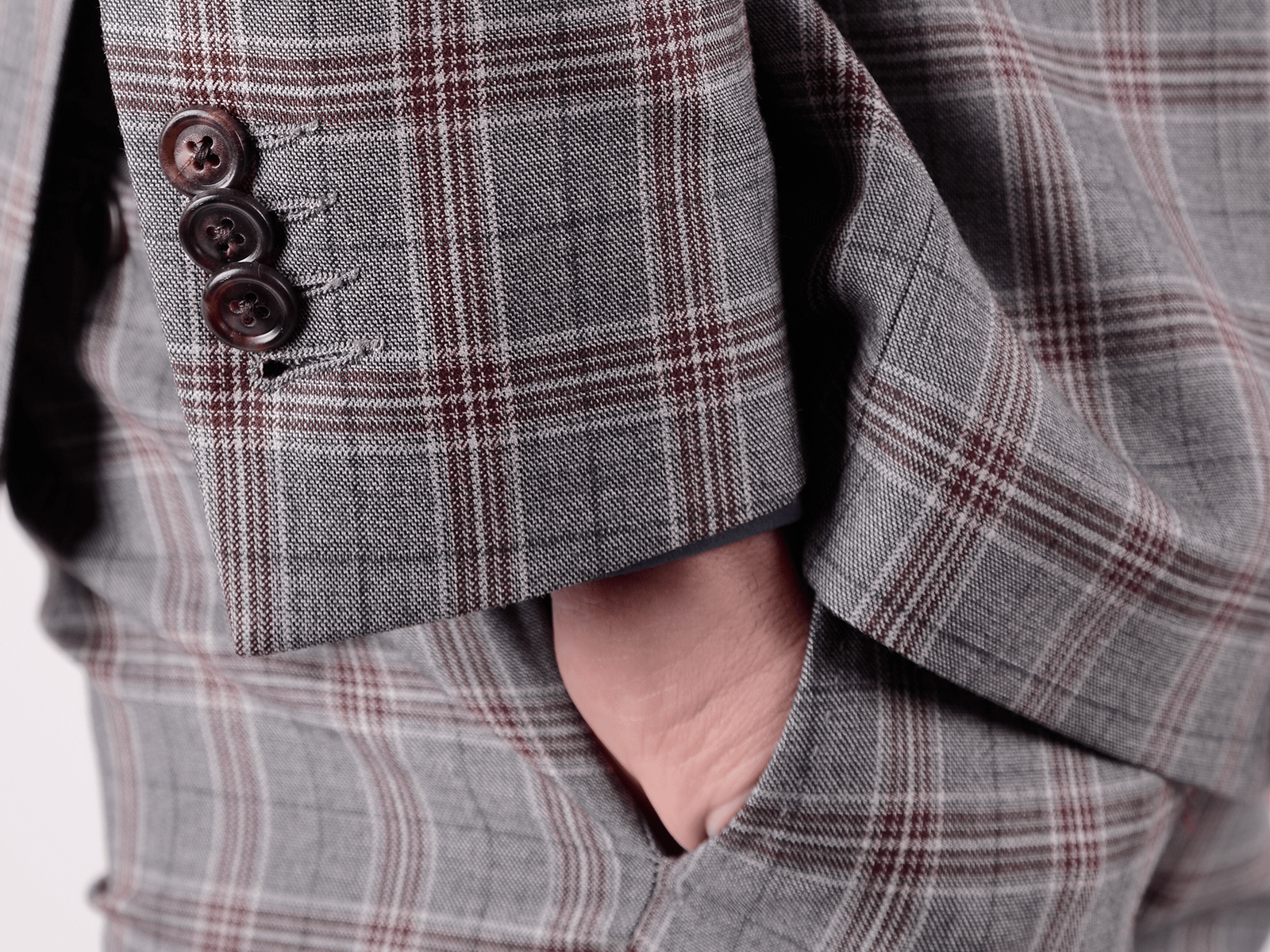 Detail on a 3 button jacket sleeve and hand in pocket