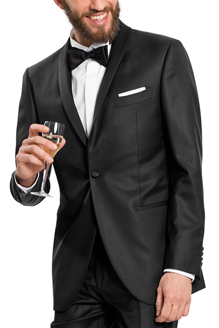Uomo con flute di champagne indossa uno smoking nero da uomo su misura, camicia bianca, pochette bianca e papillon nero