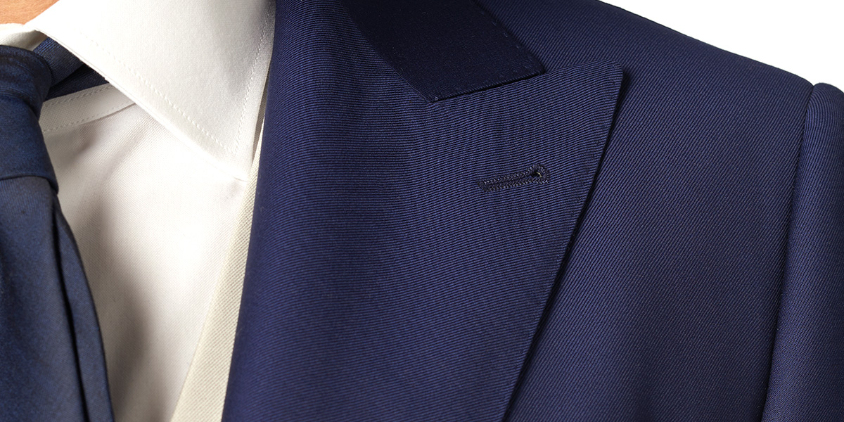 Pointed lapel detail on a two-button blue jacket