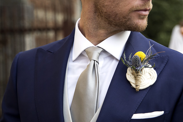 Man wears silver silk tie with blue tailored suit for ceremony