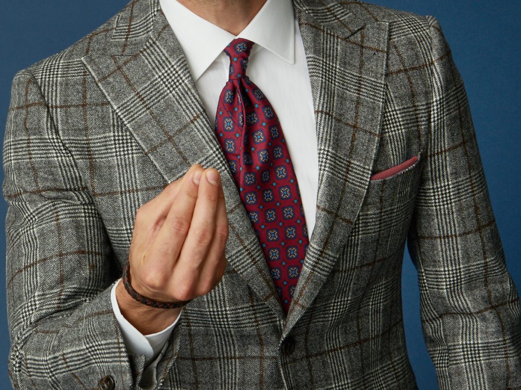 Detail on a Prince of Wales men's jacket, white shirt and pocket handkerchief coordinated with the tie
