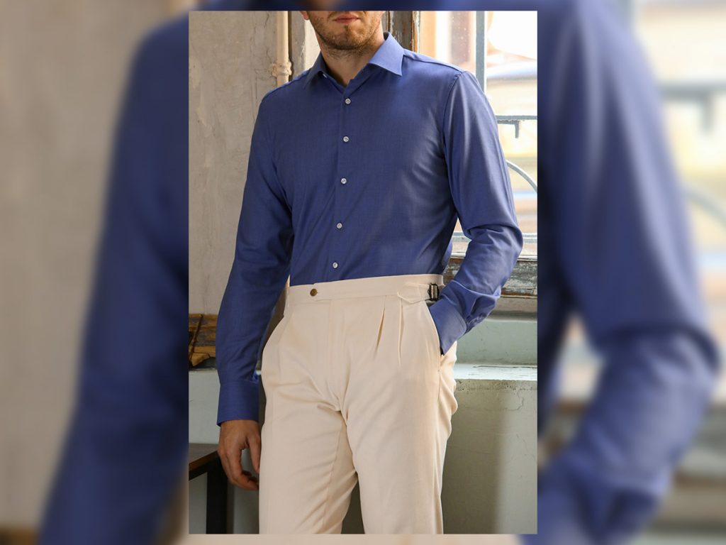 Camicia in lana blu chiara indossata con un paio di pantaloni classici color panna